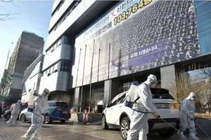Nhân viên y tế đang tiến hành khử trùng bên ngoài nhà thờ ở TP Daegu. Ảnh: REUTERS