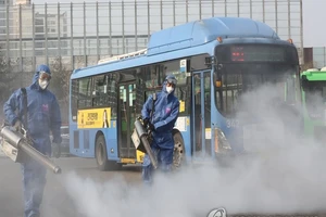 Các nhân viên y tế Hàn Quốc khử trùng tại một bến xe buýt ở thủ đô Seoul hôm 20-2. Ảnh: YONHAP