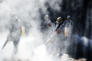 Nhân viên y tế tiến hành khử trùng đường phố tỉnh Tứ Xuyên ngày 23-2. Ảnh: REUTERS