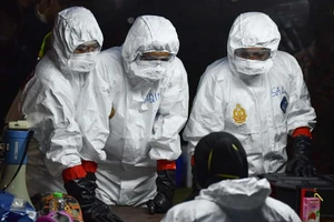 Các nhân viên y tế hướng dẫn một người nghi nhiễm COVID-19 kê khai lịch sử đi lại tại một bệnh viện ở Malaysia ngày 26-2. Ảnh: REUTERS 