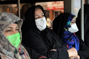 Phụ nữ Iran đeo khẩu trang khi đứng chờ xe bus ở thủ đô Tehran (Iran) ngày 26-2. Ảnh: AP