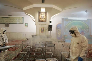 Nhân viên y tế khử trùng Nhà thờ Imam Reza ở TP Mashhad, Iran ngày 1-3. Ảnh: REUTERS