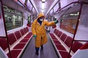 Nhân viên y tế khử trùng một toa tàu điện ở bang Georgia (Mỹ) ngày 2-3. Ảnh: AFP 