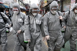 Nhân viên y tế khử trùng đường phố thủ đô Seoul (Hàn Quốc) ngày 4-3. Ảnh: AFP