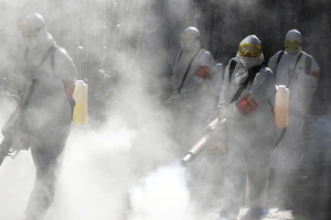 Nhân viên y tế khử trùng đường phố thị trấn Bạc Châu, Trung Quốc hồi đầu tháng 2. Ảnh: AFP