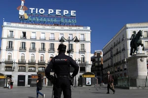 Một cảnh sát Tây Ban Nha đứng gác tại quảng trường Sol ở TP Madrid (Tây Ban Nha) ngày 10-3. Ảnh: AP