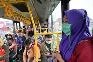 Người dân Indonesia đeo khẩu trang trên xe buýt như một biện pháp phòng dịch COVID-19. Ảnh: AFP