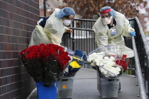 Hai nhân viên y tế trước lối vào phòng cấp cứu Bệnh viện Elmhurst thuộc bang Elmhurst, Mỹ ngày 21-3. Ảnh: AP 