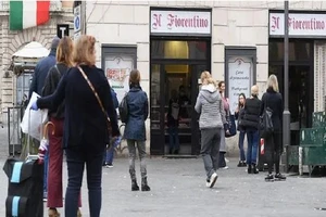 Người dân xếp hàng bên ngoài một cửa hàng bán thịt tại quảng trường Campo de Fiori ở thủ đô Rome (Ý) trong thời gian phong tỏa. Ảnh: REUTERS