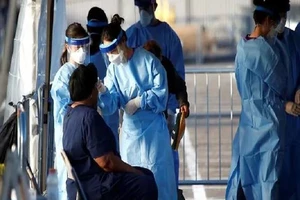 Các sinh viên y khoa của trường Đại học Touro Nevada đo thân nhiệt của một người tại bãi đỗ xe là khu vực cách ly ở TP Las Vegas, bang Nevada (Mỹ). Ảnh: REUTERS