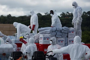 Hàng viện trợ của Úc được các nhân viên sân bay Port Vila bốc dỡ từ máy bay RAAF C-17A hôm 13-4. Ảnh: REUTERS