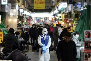 Nhân viên y tế khử trùng một khu chợ ở thủ đô Seoul, Hàn Quốc ngày 24-2. Ảnh: AFP