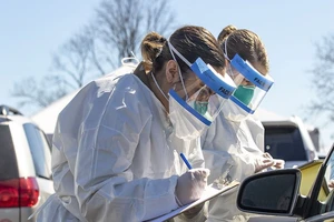 Hai nhân viên y tế ghi nhận thông tin tại một trạm kiểm soát dịch ở thành phố New York (Mỹ). Ảnh: HPW