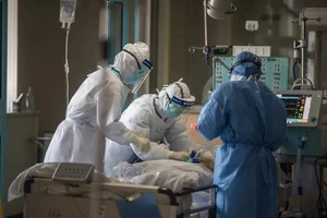 Các bác sĩ ở Bệnh viện số 1 Vũ Hán điều trị cho một ca nhiễm COVID-19 trong phòng chăm sóc tích cực hôm 22-2. Ảnh: TÂN HOA XÃ