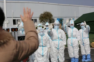 Bệnh nhân COVID-19 điều trị thành công vẫy tay chào các y bác sĩ ở Bệnh viện Lôi Thần Sơn thuộc TP Vũ Hán, Trung Quốc hồi tháng 3-2020. Ảnh: REUTERS