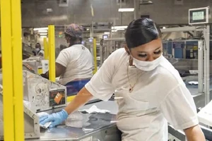 Nhân viên ngành bưu điện ở TP Los Angeles, bang California đi làm trở lại. Ảnh: AFP