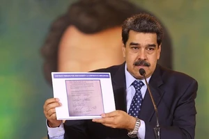 Tổng thống Venezuela Nicolas Maduro giơ bản chụp văn bản được cho là hợp đồng giữa công ty Silvercorp USA với lãnh đạo phe đối lập Juan Guaido. Ảnh: AP