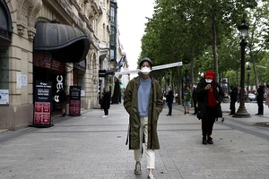 Giãn cách xã hội bằng "chiếc mũ 1 mét". Ảnh: EPA