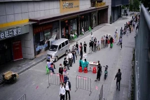 Người dân Vũ Hán xếp hàng chờ được xét nghiệm COVID-19 tại một điểm xét nghiệm ngoài trời hôm 16-5. Ảnh: REUTERS