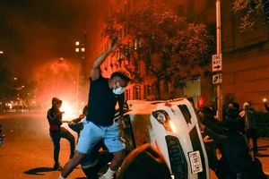 Người biểu tình đập phá xe cảnh sát ở thủ đô Washington, Mỹ tối ngày 1-6. Ảnh: REUTERS