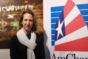 Bà Tara Joseph - Trưởng Phòng Thương mại Mỹ tại Hong Kong - chụp hình bên cạnh logo của văn phòng này. Ảnh: SCMP