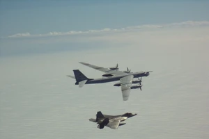 Máy bay F-22 của Mỹ (nhỏ hơn) theo sát máy bay ném bom Tu-95MS của Nga (lớn hơn) bay gần bang Alaska (Mỹ) hôm 10-6. Ảnh: NORAD