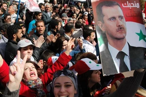 Người dân Syria tuần hành ủng hộ Tổng thống Bashar al-Assad ở thủ đô Damascus tháng 3-2012. Ảnh: REUTERS