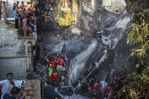 Các nhân viên cứu hộ nỗ lực tìm kiếm người sống sót sau tai nạn máy bay hôm 22-5 ở TP Karachi. Ảnh: AP