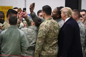 Tổng thống Mỹ Donald Trump (bên phải, áo đen) chụp hình cùng các binh sĩ Mỹ ở căn cứ Ramstein (Đức) năm 2018. Ảnh: REUTERS