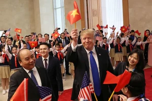 Tổng thống Donald Trump cầm lá cờ Việt Nam vẫy chào cùng Thủ tướng Nguyễn Xuân Phúc khi tham dự thượng đỉnh Mỹ - Triều tại thủ đô Hà Nội hồi tháng 2-2019. Ảnh: REUTERS