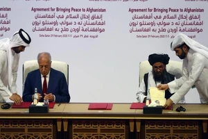 Trưởng đoàn đàm phán Taliban - ông Mullah Abdul Ghani Baradar ký thỏa thuận với đặc phái viên Mỹ về vấn đề Afghanistan MỹZalmay Khalilzad vào ngày 29-2-2020 tại Doha (Qatar). Ảnh: REUTERS/Ibraheem al Omari