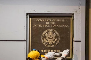 Nhân viên Trung Quốc tháo biển hiệu của lãnh sự quán Mỹ ở Thành Đô. Ảnh: EPA-EFE