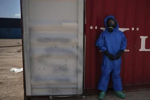 Nhân viên cứu hộ của Pháp đứng cạnh thùng chứa hóa chất dễ gây cháy tại cảng Beirut. Ảnh: AP Photo/Felipe Dana