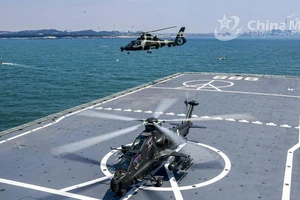 Trực thăng tấn công của Trung Quốc diễn tập chung với tàu đổ bộ lớp Type 071. Ảnh: CHINAMIL