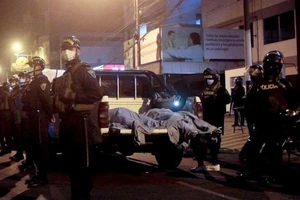 Hai thi thế được cảnh sát đưa ra ngoài từ hiện trường hỗn loạn. Ảnh: AFP