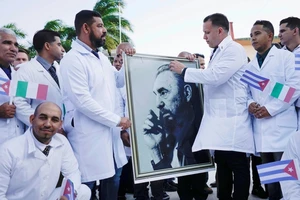 Các bác sĩ Cuba chụp hình với ảnh cố lãnh tụ Fidel Castro trước khi sang hỗ trợ Ý chống dịch COVID-19 hồi cuối tháng 3. Ảnh: REUTERS