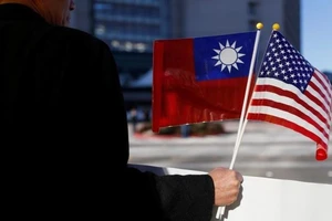 Một người đàn ông cầm cờ Mỹ và Đài Loan.