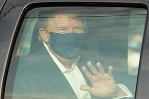 Tổng thống Donald Trump vẫy tay chào người ủng hộ bên ngoài Walter Reed trong chuyến thăm bất ngờ ngày 4-10.