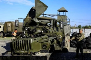 Các binh sĩ kiểm tra một chiếc xe tải quân sự bị hư hỏng của Armenia do bị quân đội Azerbaijan bắt giữ trong cuộc giao tranh gần thành phố Barda.