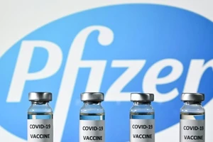Những lọ vaccine ngừa COVID-19 đặc trước logo tập đoàn dược phẩm Pfizer.