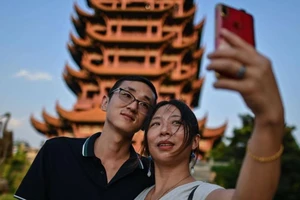 Khách du lịch chụp hình tại một điểm tham quan ở Vũ Hán.