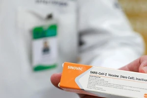 Một nhân viên y tế cầm vỏ chứa vaccine ngừa COVID-19 của công ty dược phẩm Sinovac.