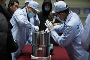 Các nhà nghiên cứu khoa học chuyển thùng chứa vật chất mặt trăng. Ảnh: TÂN HOA XÃ
