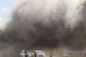 Khói bụi bốc lên sau khi xảy ra những vụ tấn công vào sân bay ở Aden, Yemen ngày 30-12.