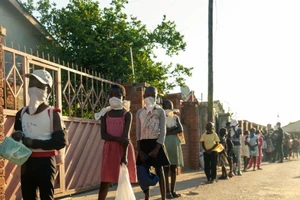 Trẻ em nghèo xếp hàng xin thức ăn ở Chitungwizaon, Zimbabwe.