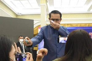Thủ tướng Prayut Chan-o-cha phun nước rửa tay vào mặt phóng viên trong cuộc họp báo ngày 9-3. Ảnh: HAYAT