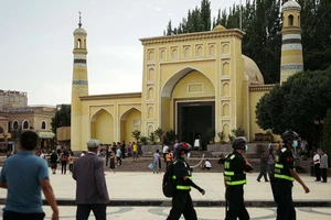 Cảnh sát Trung Quốc tuần tra trước một nhà thờ Hồi giáo ở TP Kashgar, Tân Cương hồi tháng 6-2020. Ảnh: REUTERS
