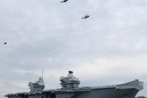 Trực thăng bay phía trên chiếc hàng không mẫu hạm mới HMS Queen Elizabeth của Hải quân Hoàng gia Anh khi nó đến Portsmouth, Anh.