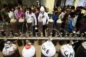 Người thân của bệnh nhân COVID-19 xếp hàng dài ở các trạm nạp oxy. Ảnh: GETTY IMAGE