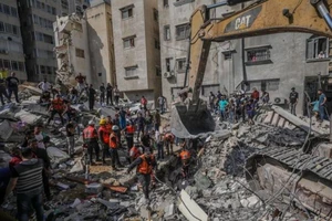 Nhân viên cứu hộ đang tìm cách đưa những thi thể nằm trong đống đổ nát do cuộc không kích của Israel.